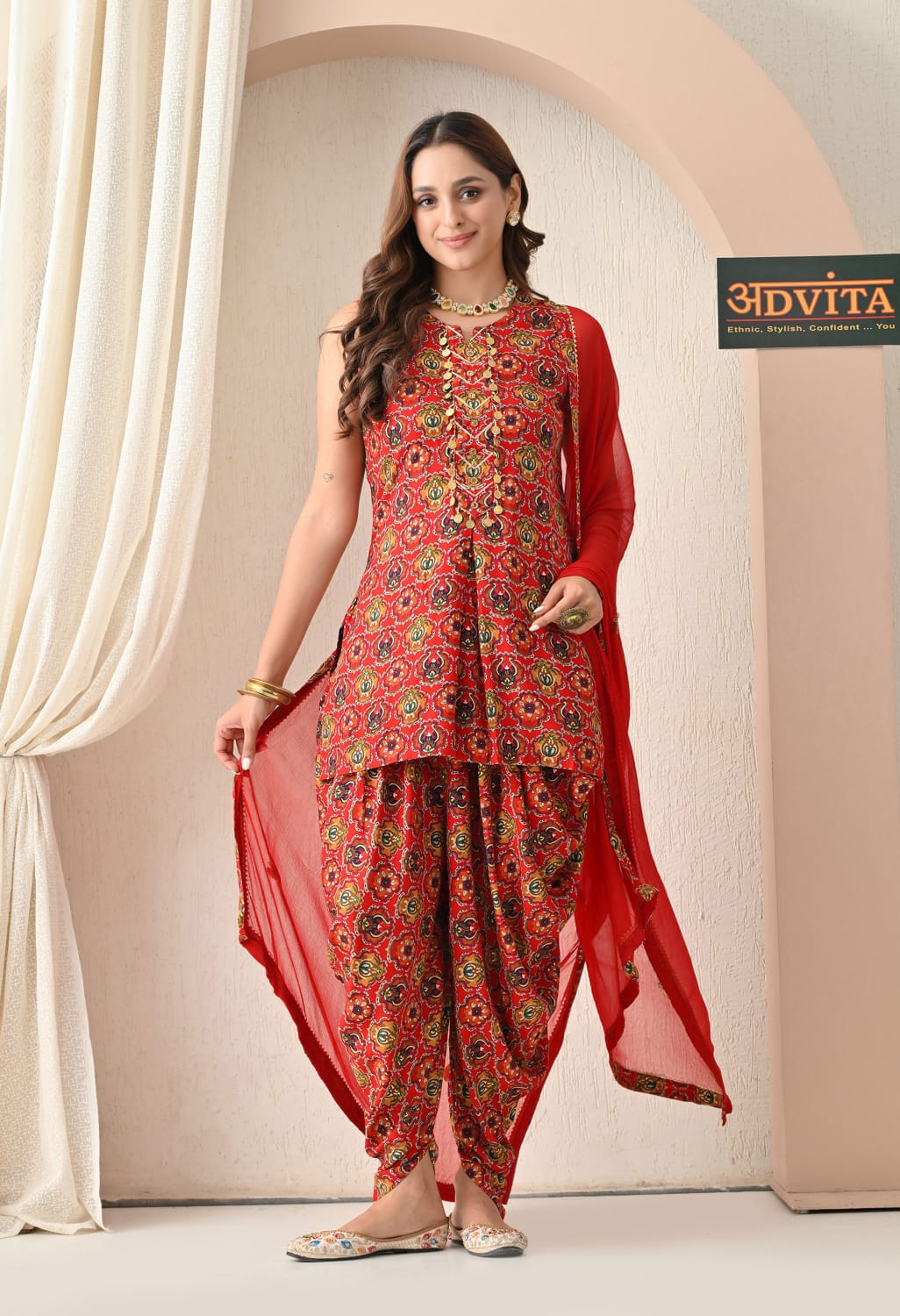 Woman wearing elegant red dhoti suit with matching dupatta