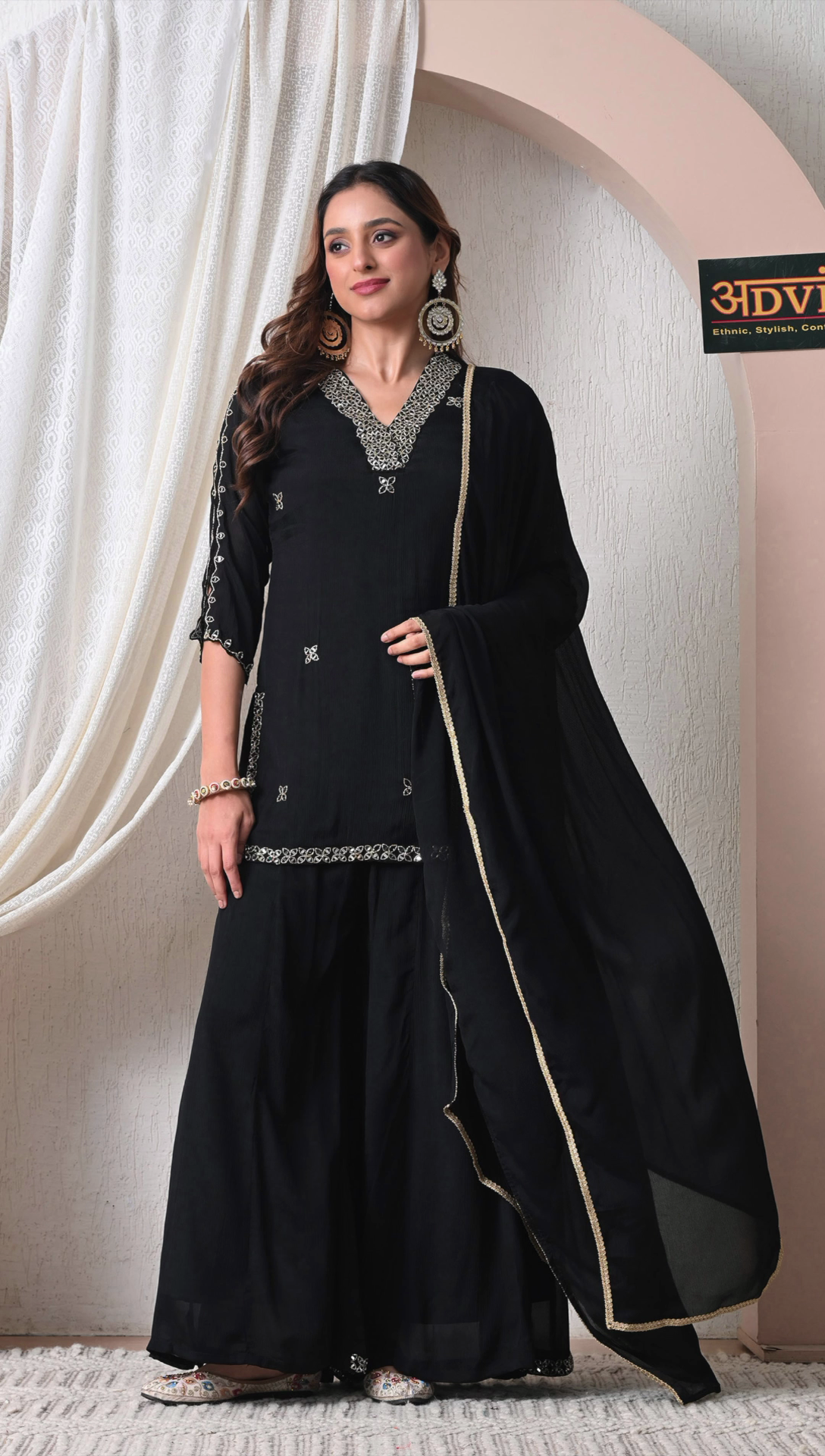 Woman wearing black chinon embroidered sharara set with dupatta