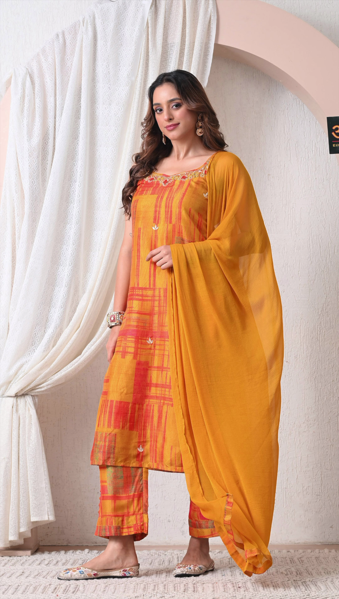 Woman wearing mustard orange muslin silk kurti set with dupatta