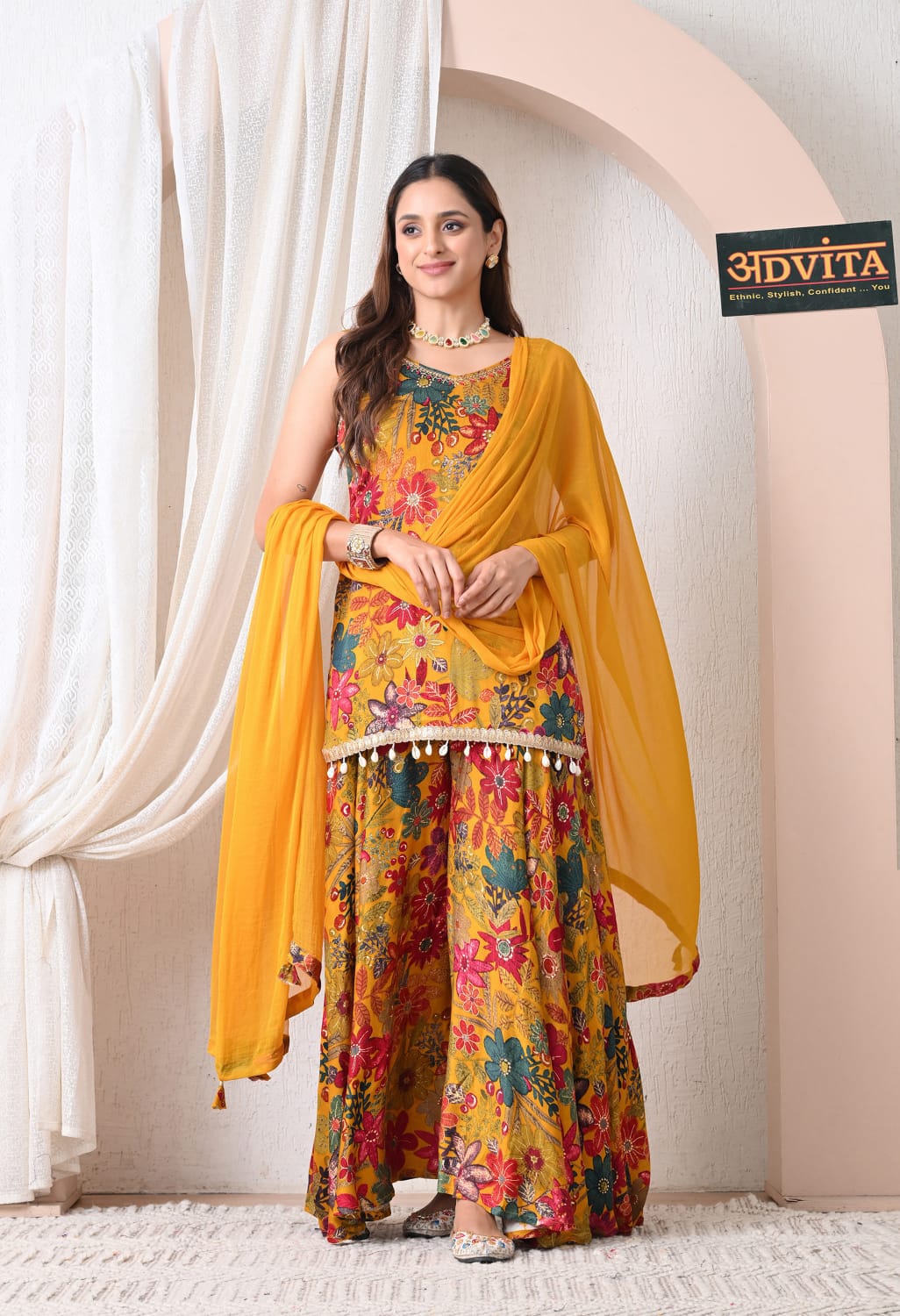 Woman wearing mustard yellow floral sharara suit with dupatta